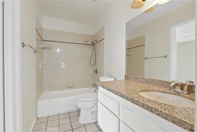 a bathroom with a granite countertop sink a toilet and shower