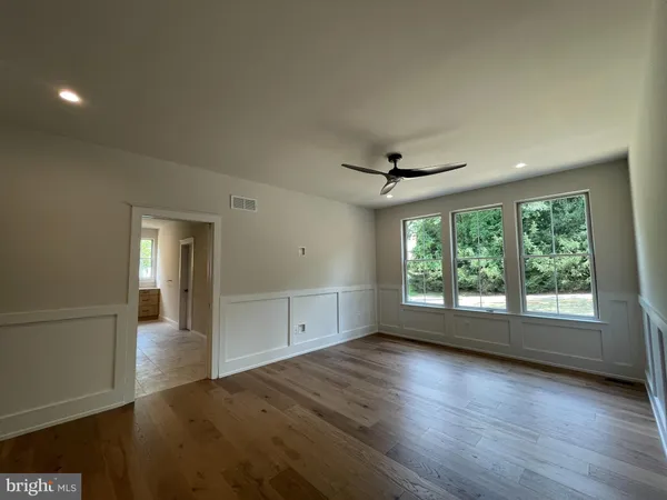 a view of a hallway with wooden floor and chandelier