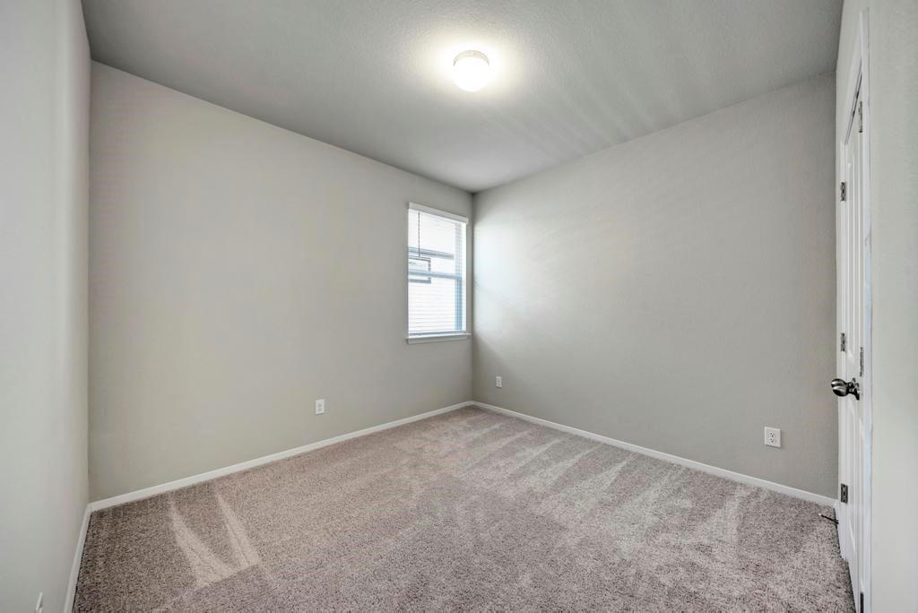 1209 Goforth Road Kyle, TX 78640 - Photo 25 of 32 A well-lit, neutral-toned room ready for personalization.