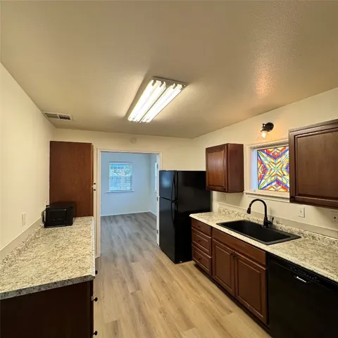 a kitchen with stainless steel appliances granite countertop a sink and a refrigerator