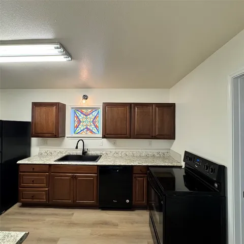 a kitchen with granite countertop a sink and cabinets