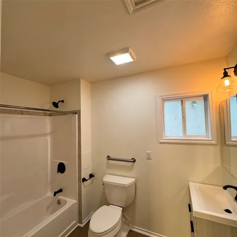 a bathroom with a toilet a sink and shower