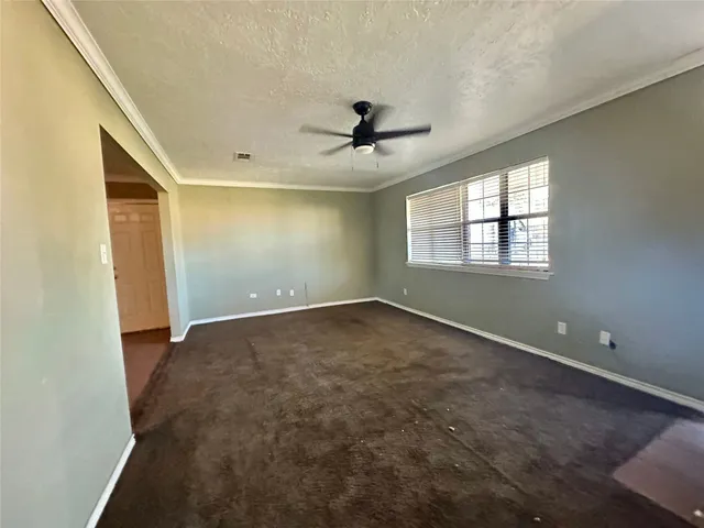 an empty room with windows and fan