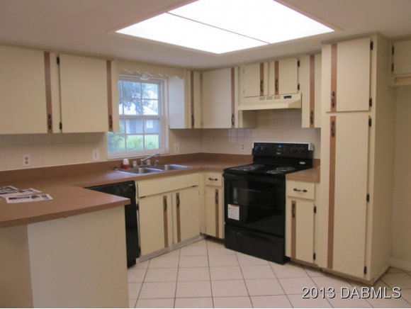 2907 Juniper Drive Edgewater, FL 32141 - Photo 5 of 12 a kitchen with stainless steel appliances granite countertop a sink stove and cabinets