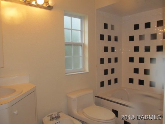 2907 Juniper Drive Edgewater, FL 32141 - Photo 8 of 12 a white toilet sitting next to a shower curtain