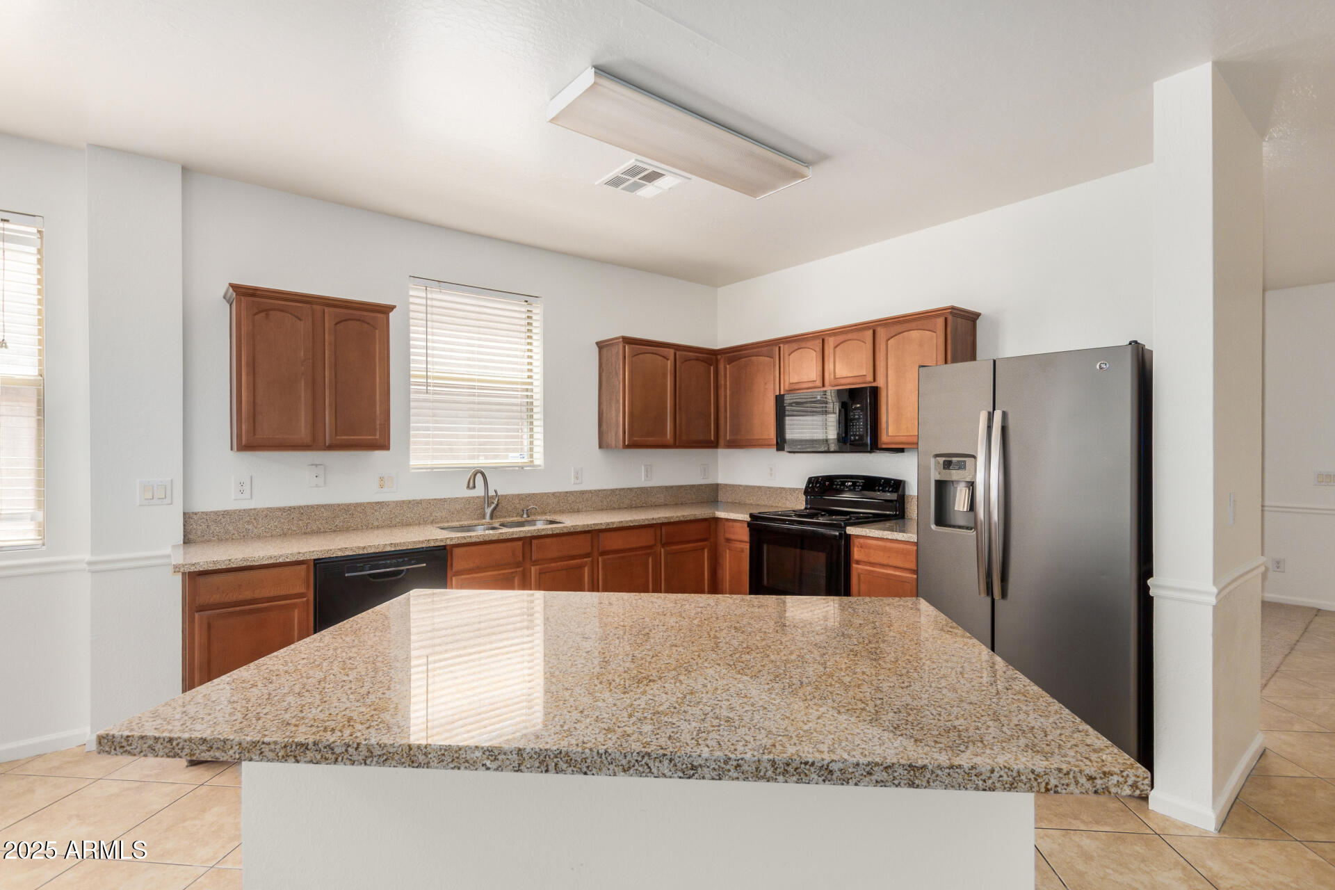 18475 North Madison Road Maricopa, AZ 85139 - Photo 12 of 40 a large kitchen with granite countertop a large counter top stainless steel appliances and cabinets