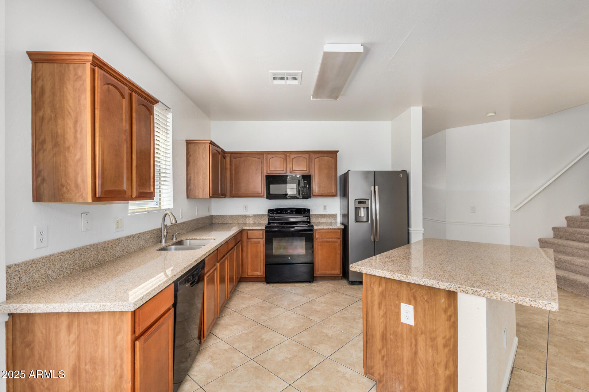 18475 North Madison Road Maricopa, AZ 85139 - Photo 13 of 40 a large kitchen with granite countertop a lot of counter space and stainless steel appliances