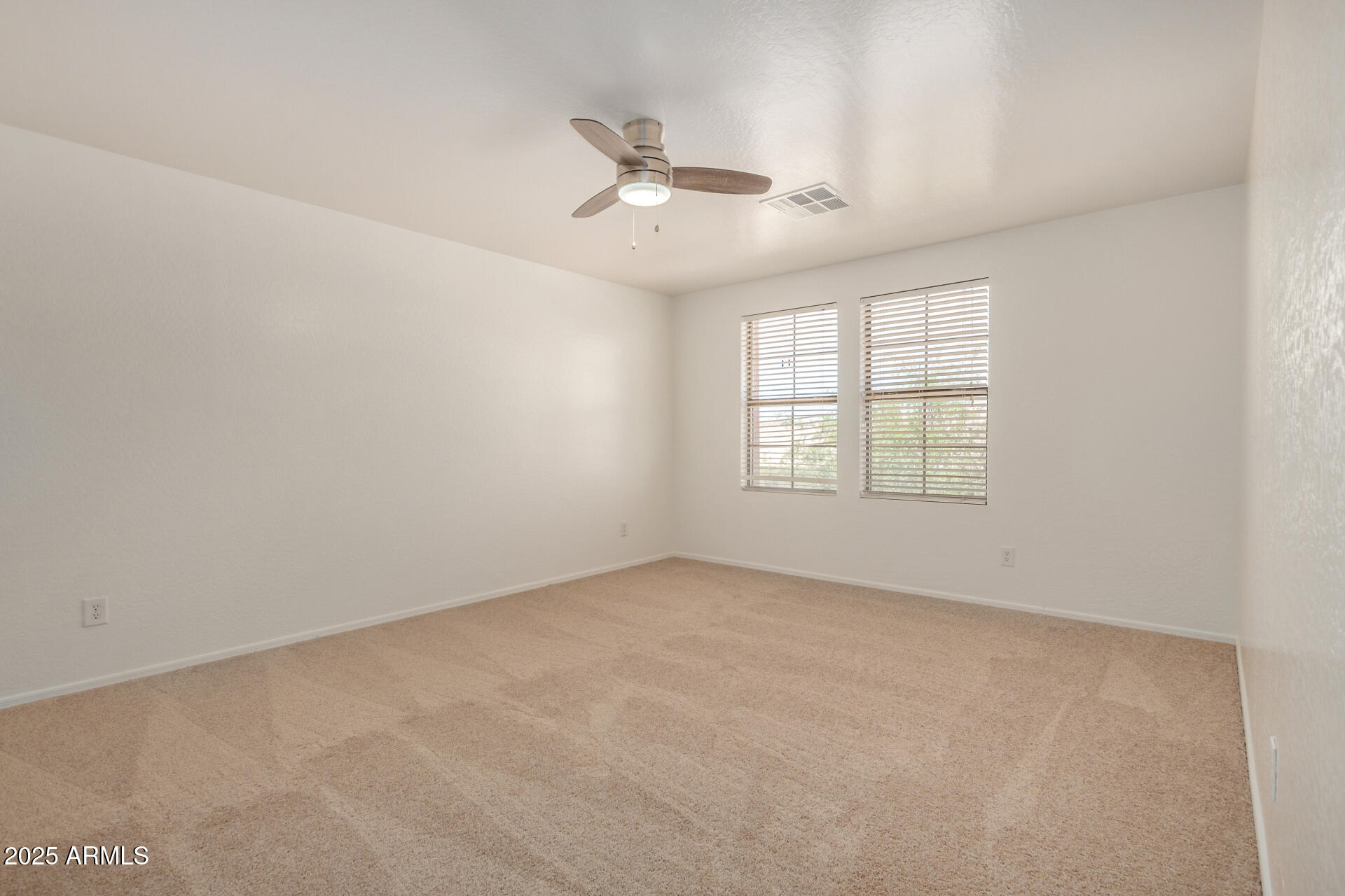 18475 North Madison Road Maricopa, AZ 85139 - Photo 28 of 40 an empty room with windows and ceiling fan
