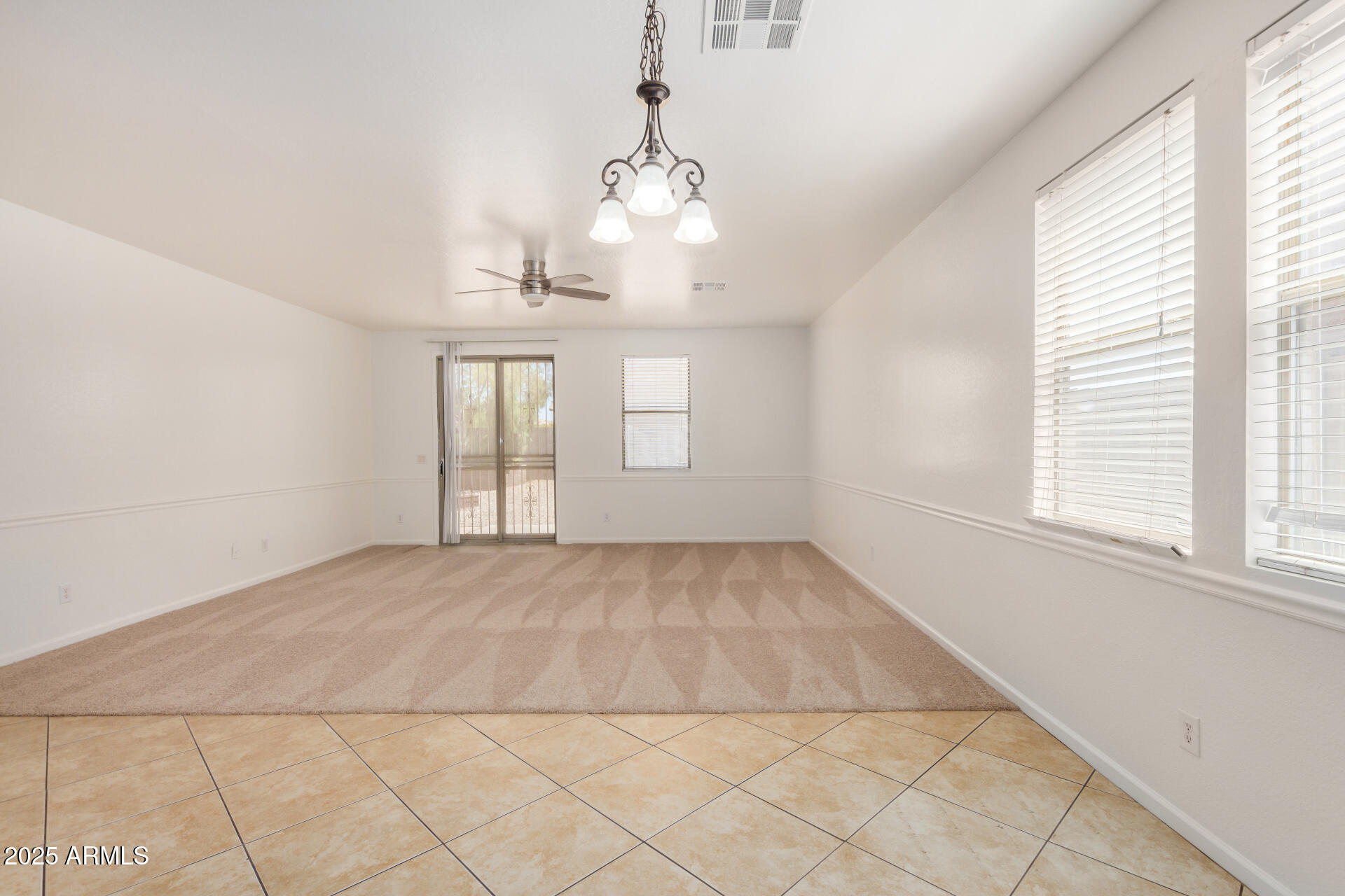 18475 North Madison Road Maricopa, AZ 85139 - Photo 9 of 40 an empty room with chandelier fan and windows