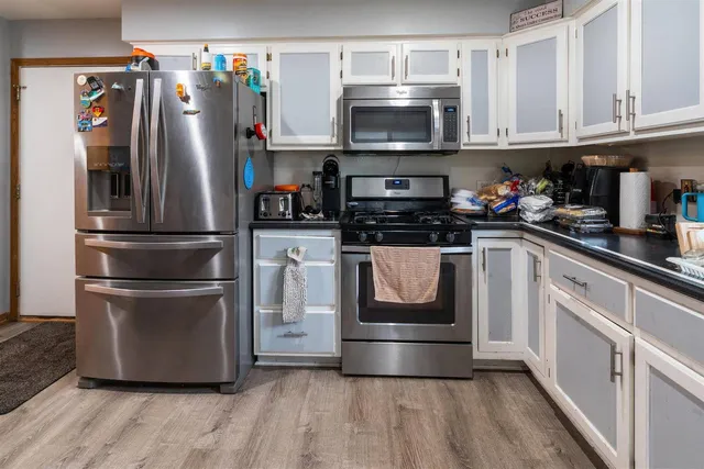 a kitchen with stainless steel appliances a refrigerator stove and microwave