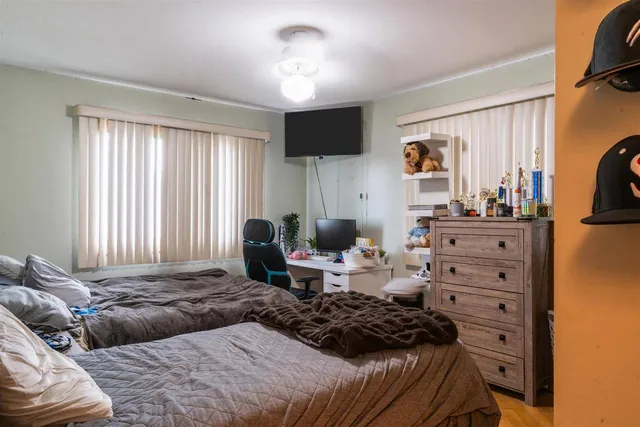 a bedroom with a bed and flat tv screen