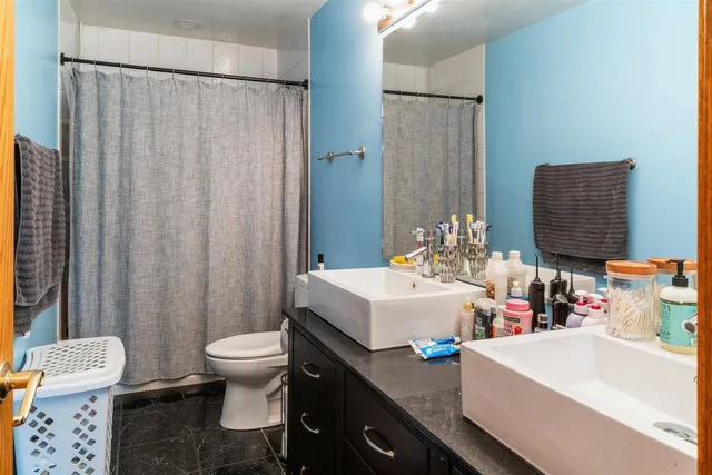 a bathroom with a sink a toilet and shower curtain