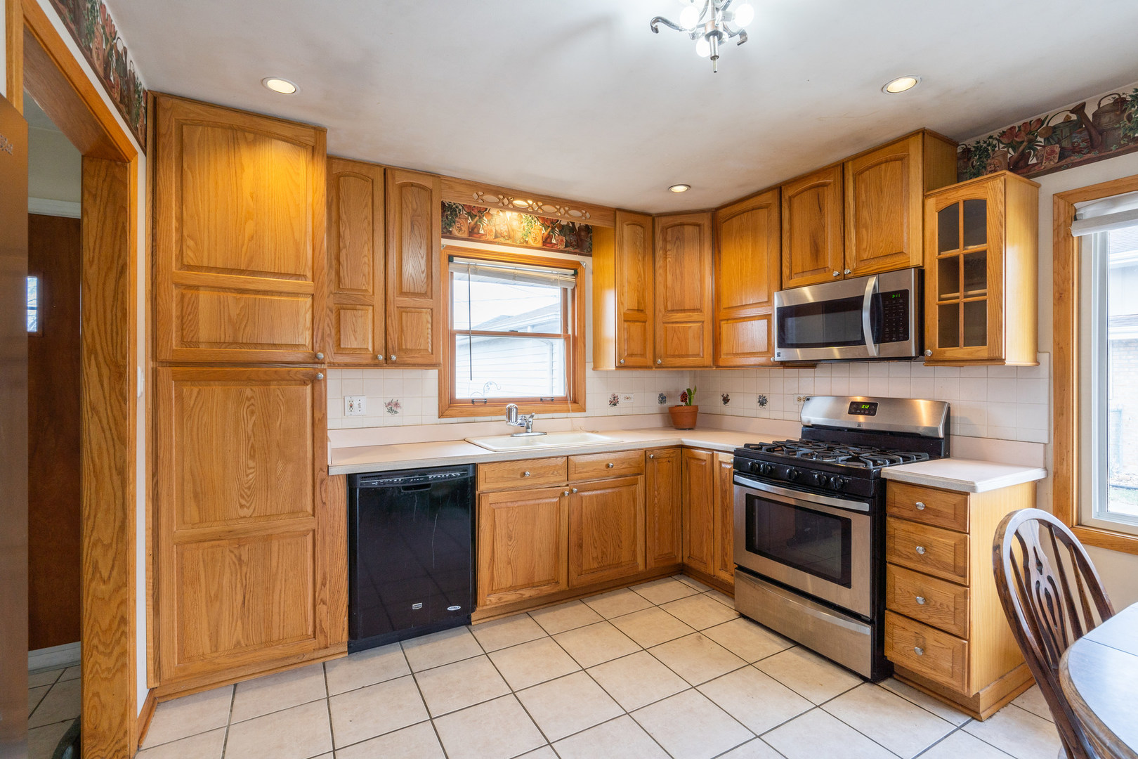 5912 109th Place Chicago Ridge, IL 60415 - Photo 13 of 21 a kitchen with stainless steel appliances granite countertop a stove top oven a sink dishwasher a dining table and chairs with wooden floor