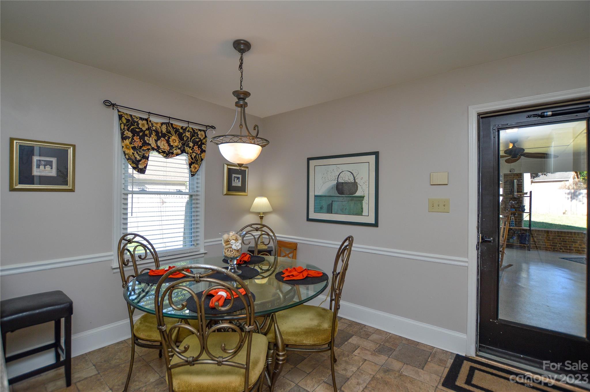 5215 Rocky River Road Charlotte, NC 28215 - Photo 15 of 33 a view of a dining room with furniture wooden floor and a chandelier