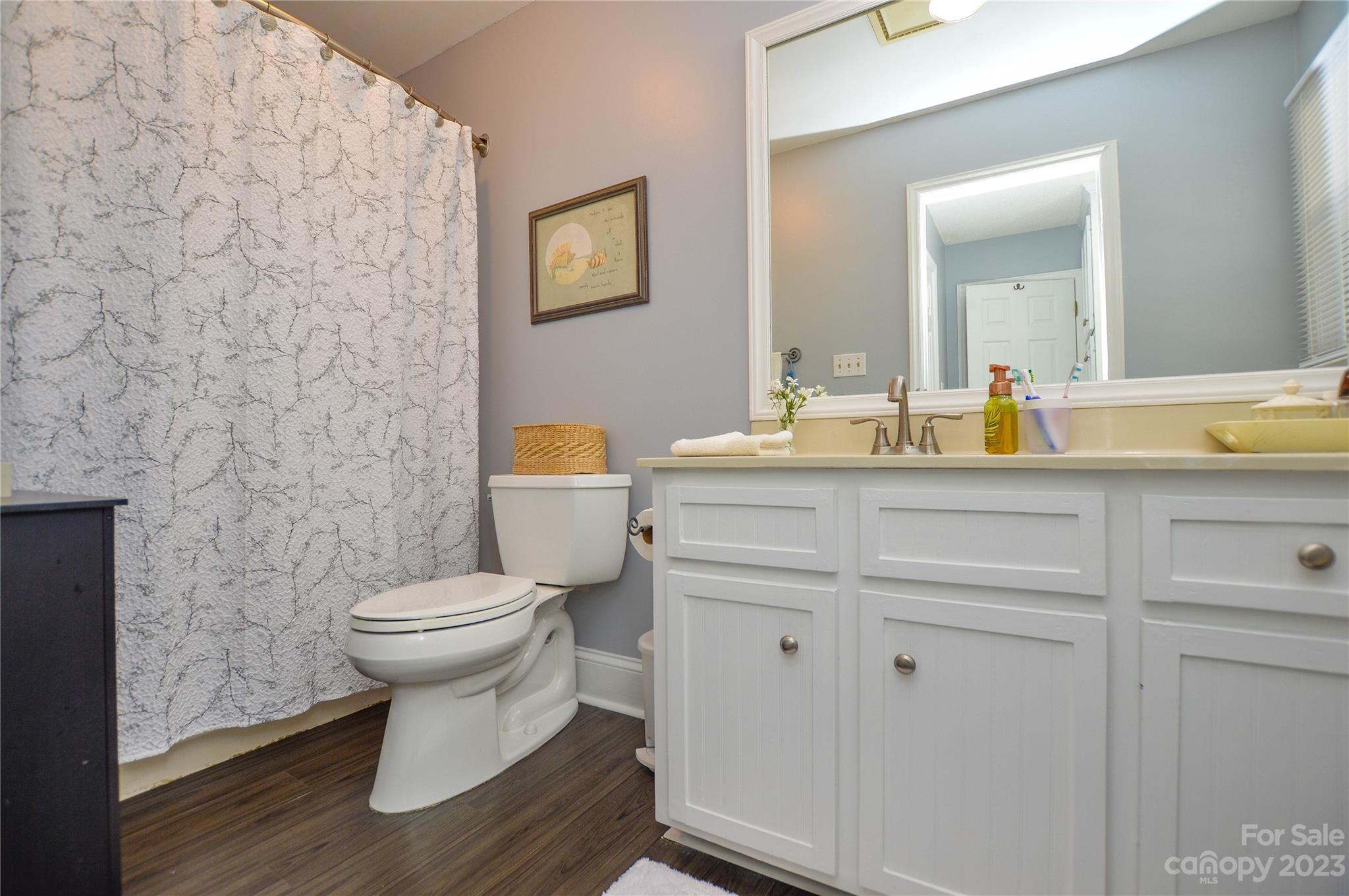 5215 Rocky River Road Charlotte, NC 28215 - Photo 23 of 33 a bathroom with a toilet sink and mirror