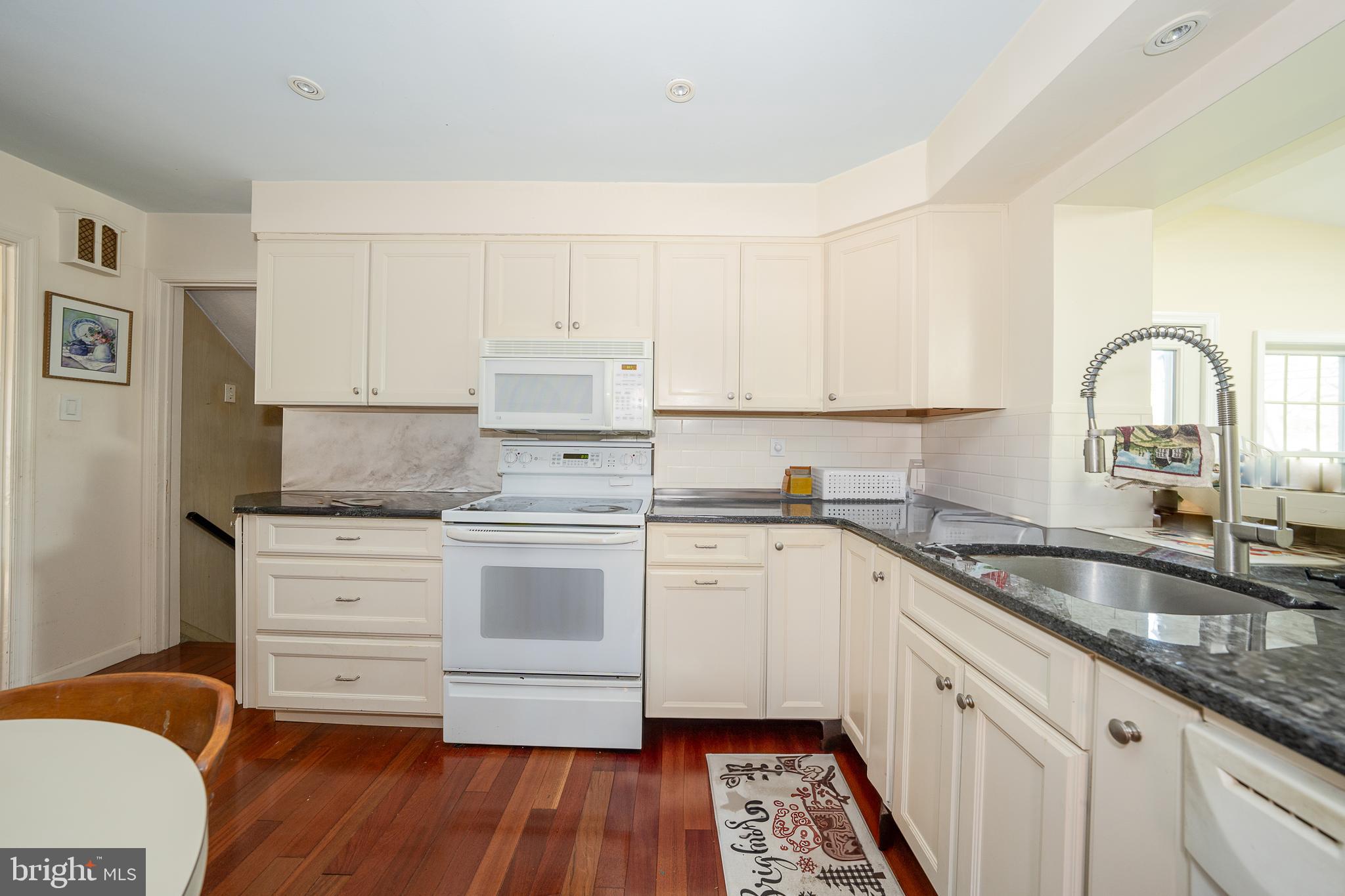 262 Lewis Road Springfield, PA 19064 - Photo 4 of 11 a kitchen with granite countertop white cabinets and white appliances