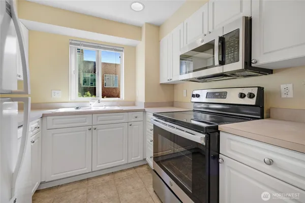 a kitchen with stainless steel appliances a stove microwave and sink