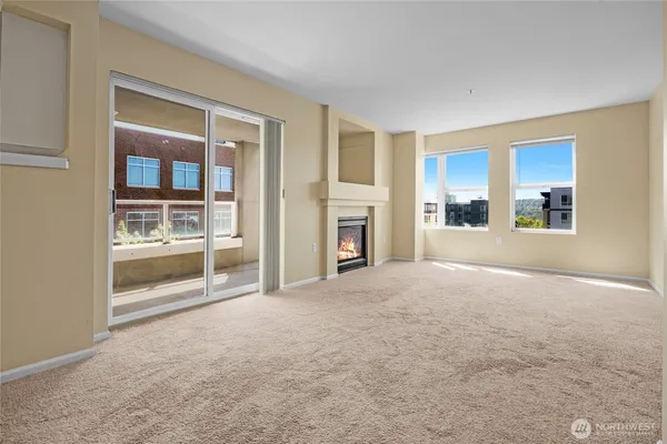 a view of an empty room with a fireplace and a window