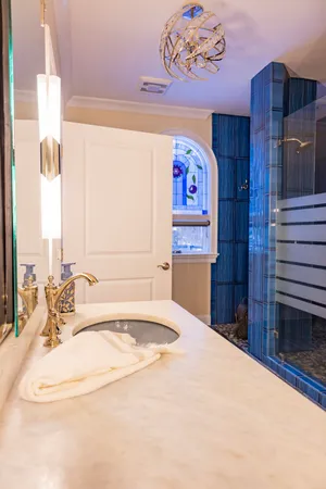 a bedroom with a bed and a large window with wooden floor