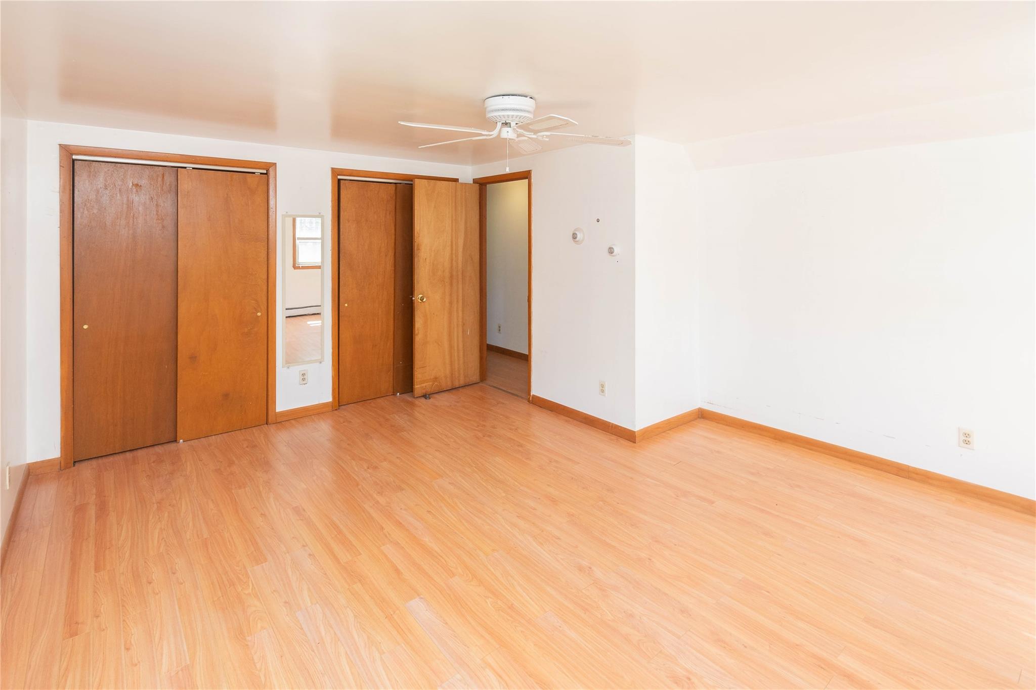 57 East Rock Cut Road Walden, NY 12586 - Photo 11 of 27 Unfurnished bedroom with multiple closets, light wood-style floors, baseboards, and a ceiling fan