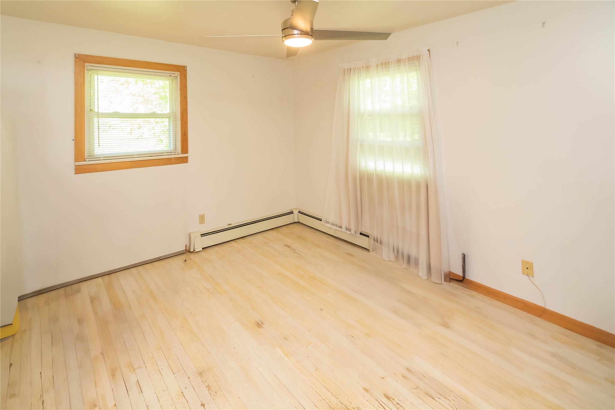 57 East Rock Cut Road Walden, NY 12586 - Photo 15 of 27 Empty room featuring light wood-type flooring, a ceiling fan, a baseboard heating unit, and baseboards