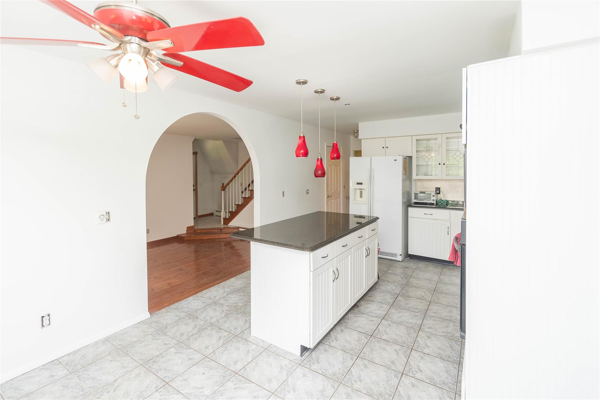 57 East Rock Cut Road Walden, NY 12586 - Photo 5 of 27 Kitchen with white refrigerator with ice dispenser, dark countertops, arched walkways, ceiling fan, and glass insert cabinets