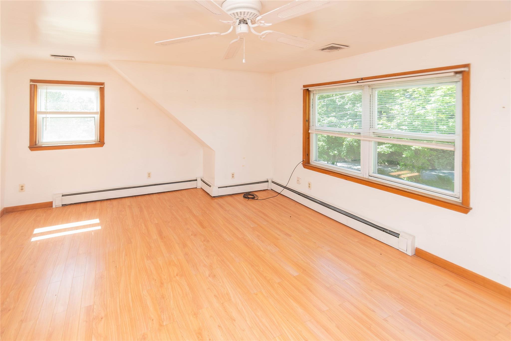 57 East Rock Cut Road Walden, NY 12586 - Photo 10 of 27 Spare room featuring a baseboard heating unit, light wood-style floors, vaulted ceiling, ceiling fan, and baseboards