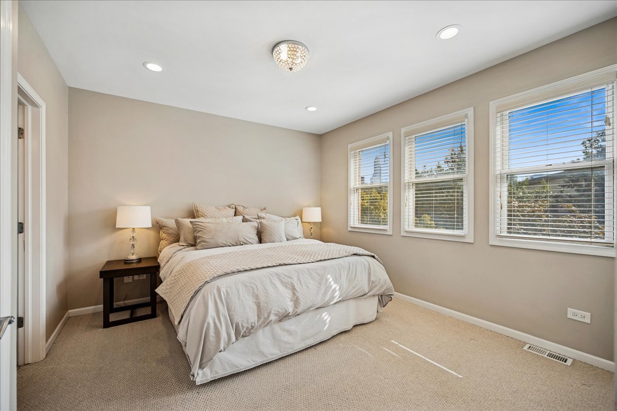 634 West Oak Street Chicago, IL 60610 - Photo 19 of 34 a spacious bedroom with a bed and a large window