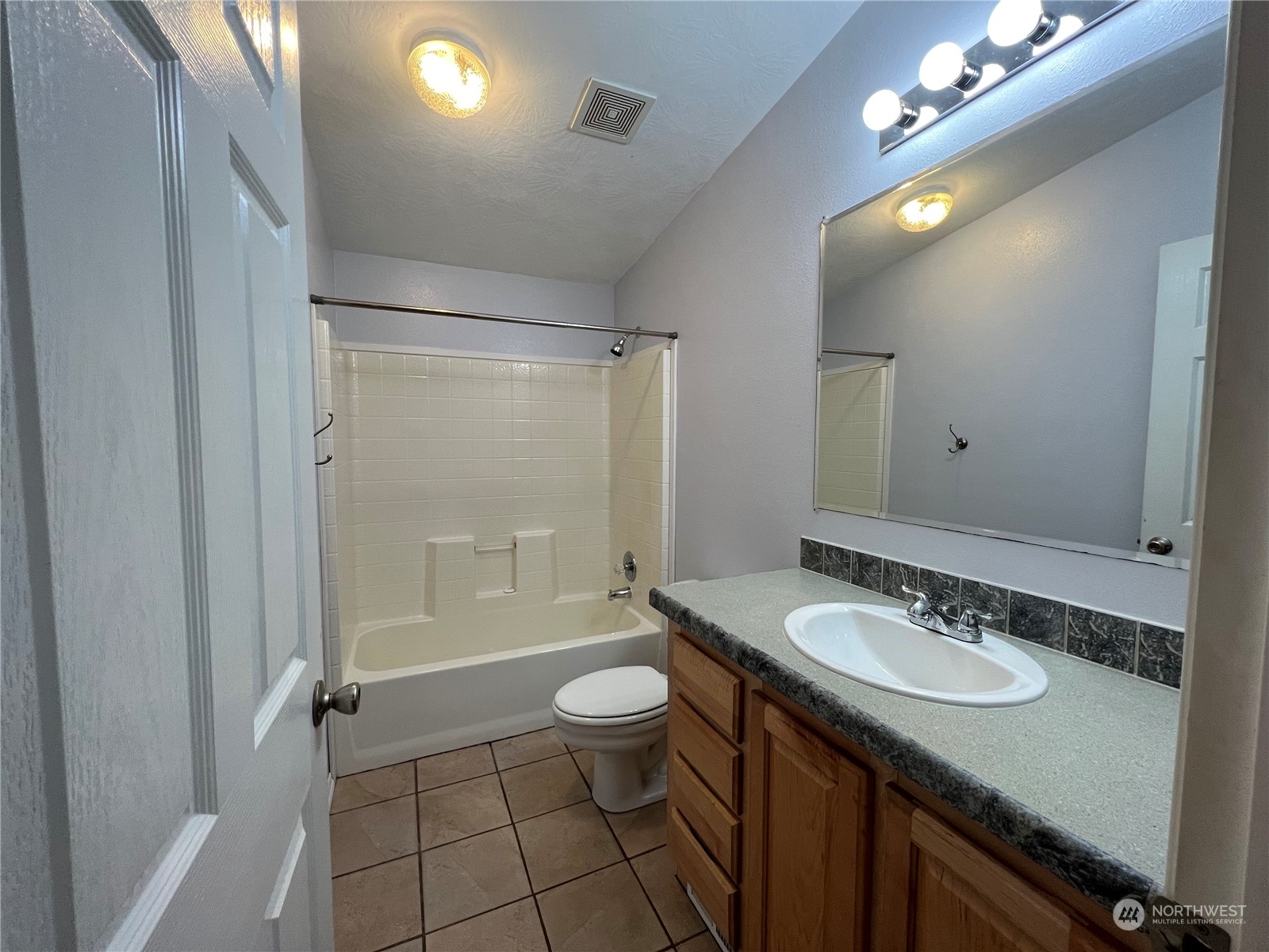 827 Cousins Road, Unit 27 Chehalis, WA 98532 - Photo 25 of 38 a bathroom with a granite countertop sink a toilet a mirror a vanity and shower
