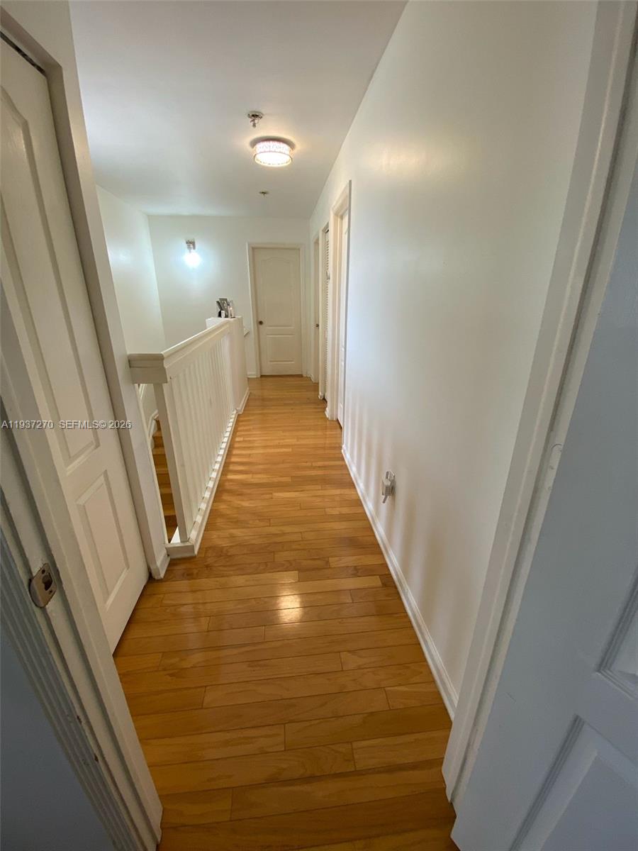 15442 Southwest 139th Street Miami, FL 33196 - Photo 17 of 27 a view of a hallway with wooden floor and stairs
