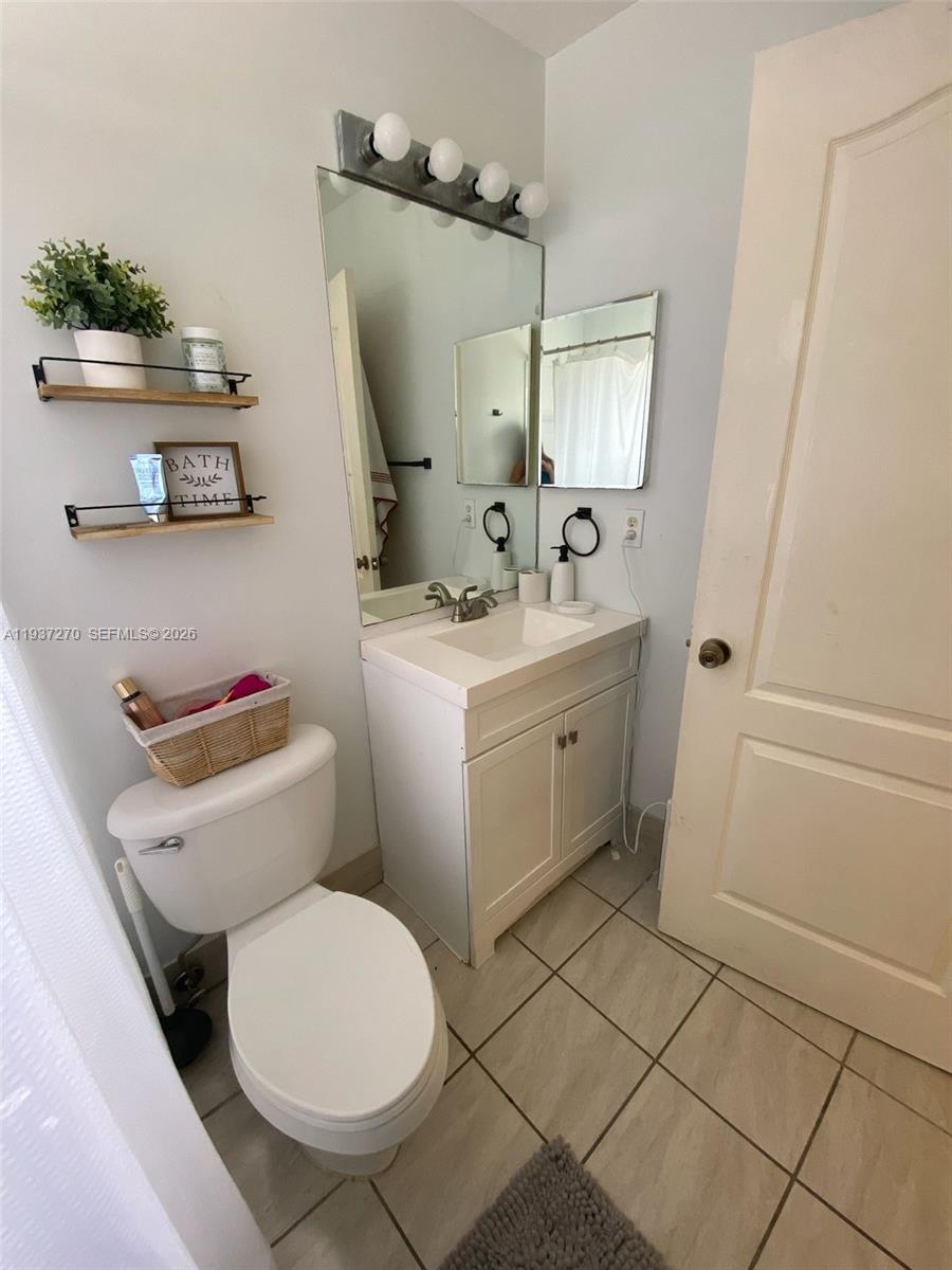 15442 Southwest 139th Street Miami, FL 33196 - Photo 18 of 27 a bathroom with a toilet a sink and a mirror
