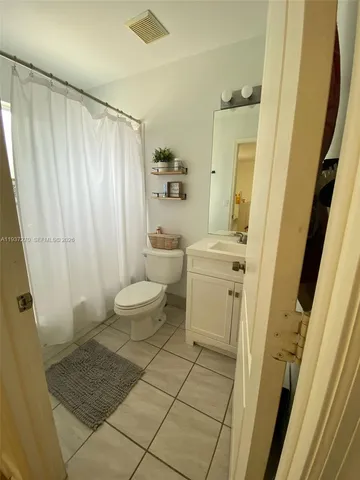 a bathroom with a sink a toilet a mirror and a shower