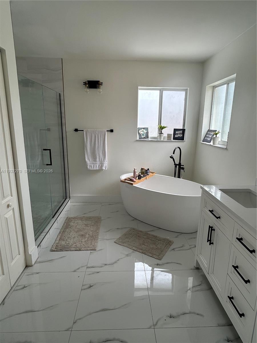 15442 Southwest 139th Street Miami, FL 33196 - Photo 21 of 27 a spacious bathroom with a tub sink and mirror