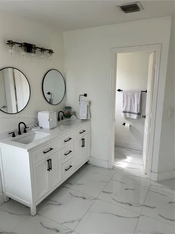 a bathroom with a granite countertop sink mirror and vanity