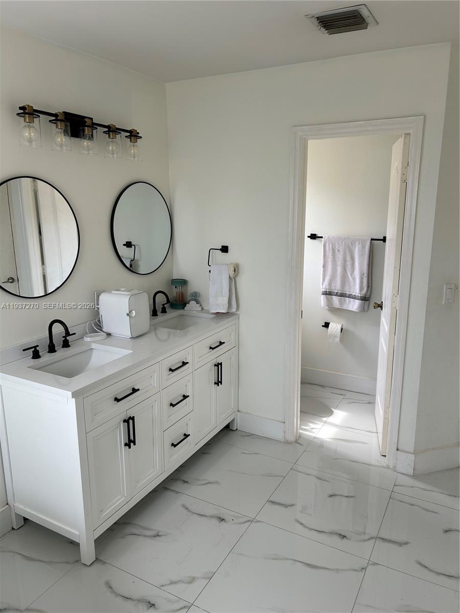15442 Southwest 139th Street Miami, FL 33196 - Photo 22 of 27 a bathroom with a granite countertop sink mirror and vanity