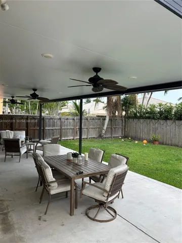 a view of a patio with chairs and table in a yard