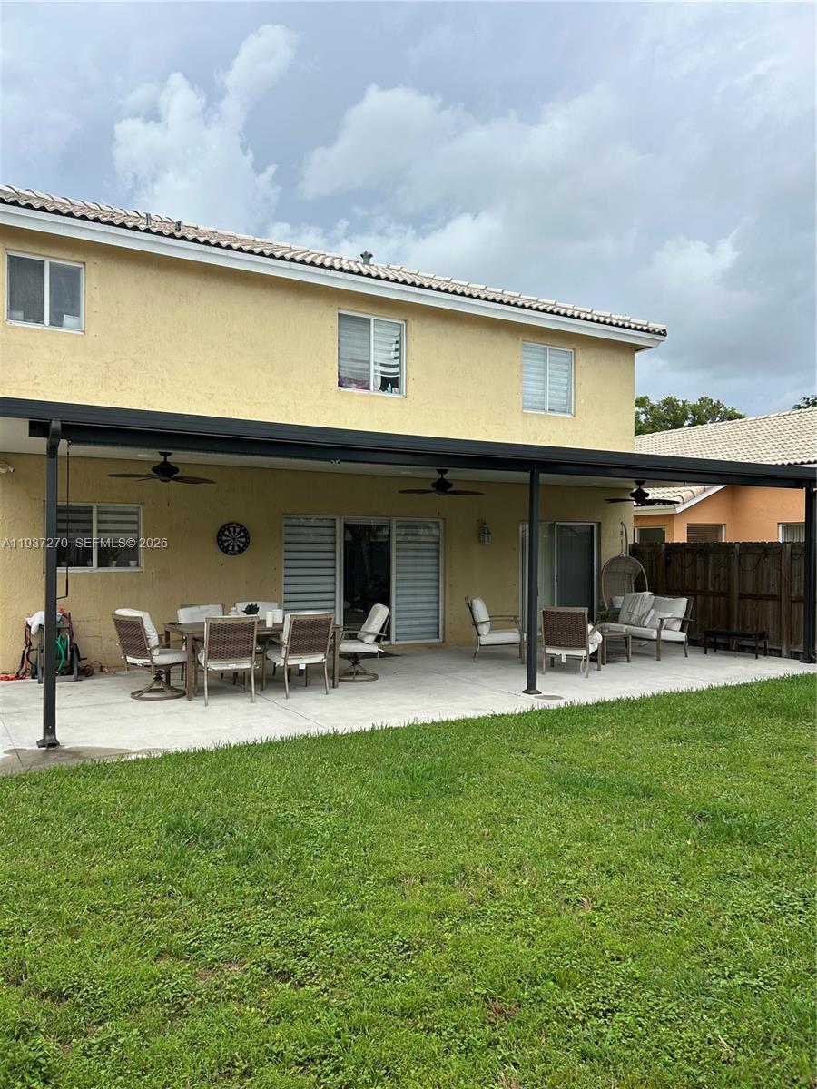 15442 Southwest 139th Street Miami, FL 33196 - Photo 26 of 27 a view of a patio with table and chairs under an umbrella