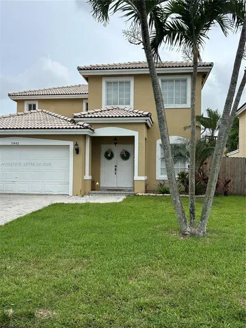 a view of a house with a yard and palm trees