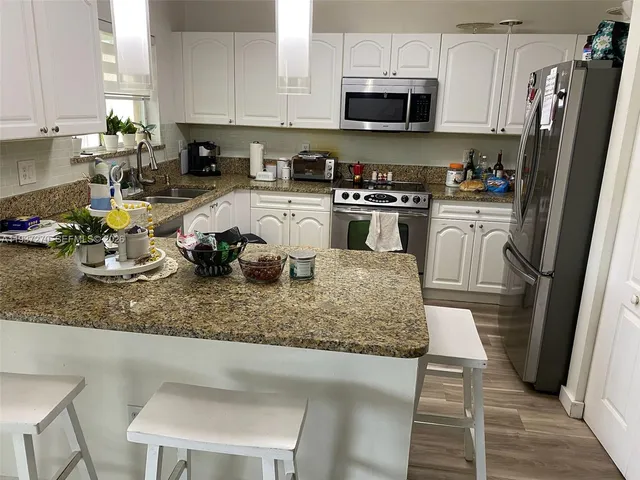 a kitchen with sink a microwave and cabinets