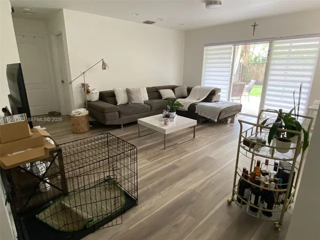 a living room with furniture a window and a flat screen tv