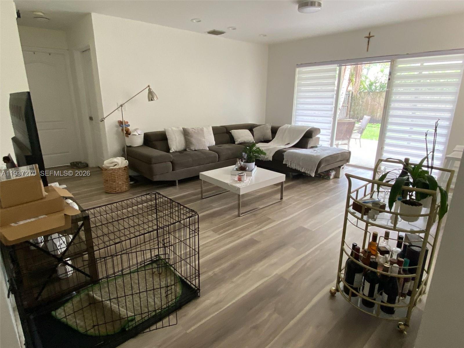 15442 Southwest 139th Street Miami, FL 33196 - Photo 10 of 27 a living room with furniture a window and a flat screen tv