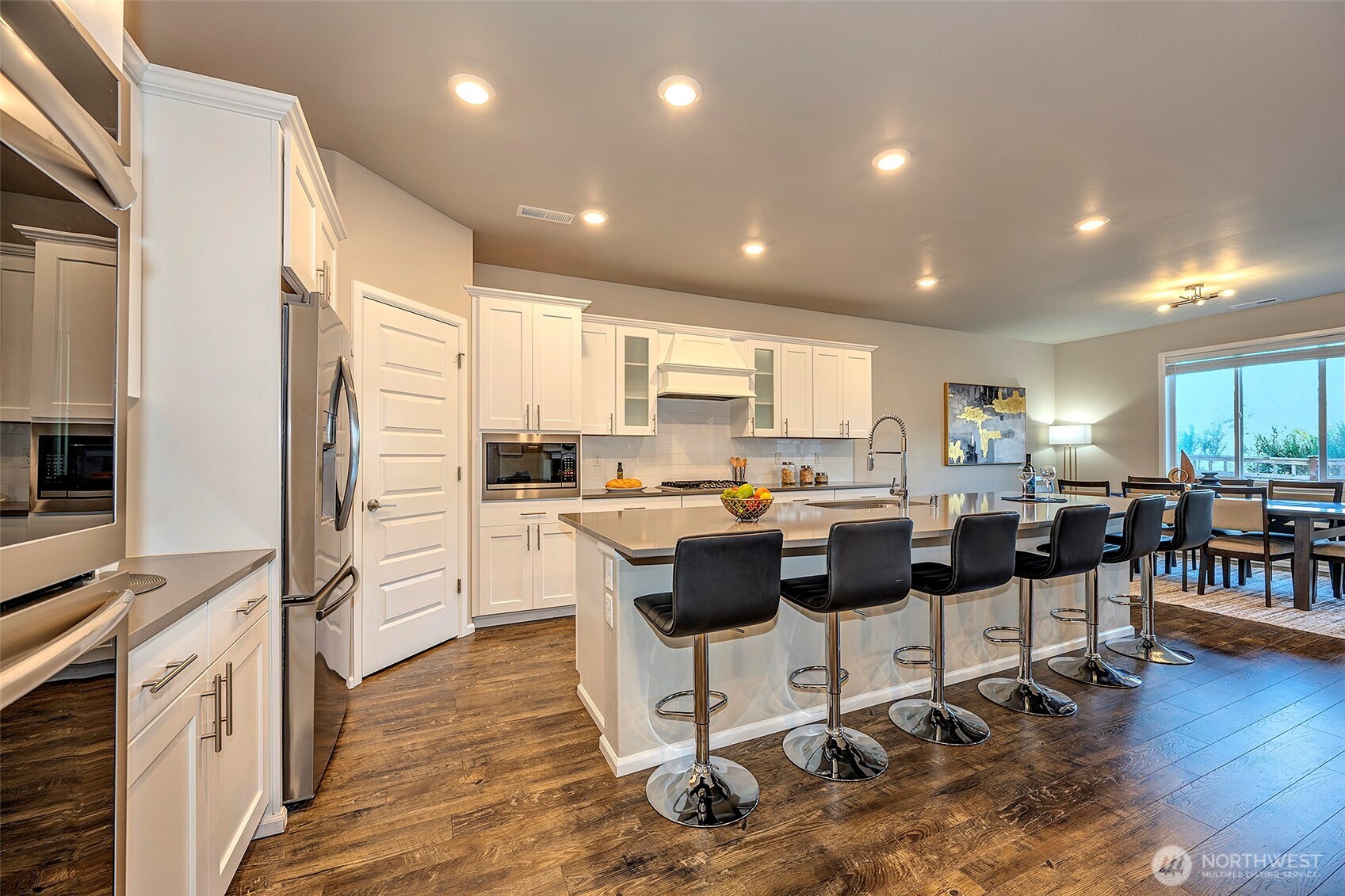 28902 239th Avenue Southeast Maple Valley, WA 98010 - Photo 17 of 36 a kitchen with a dining table chairs refrigerator and a stove top oven