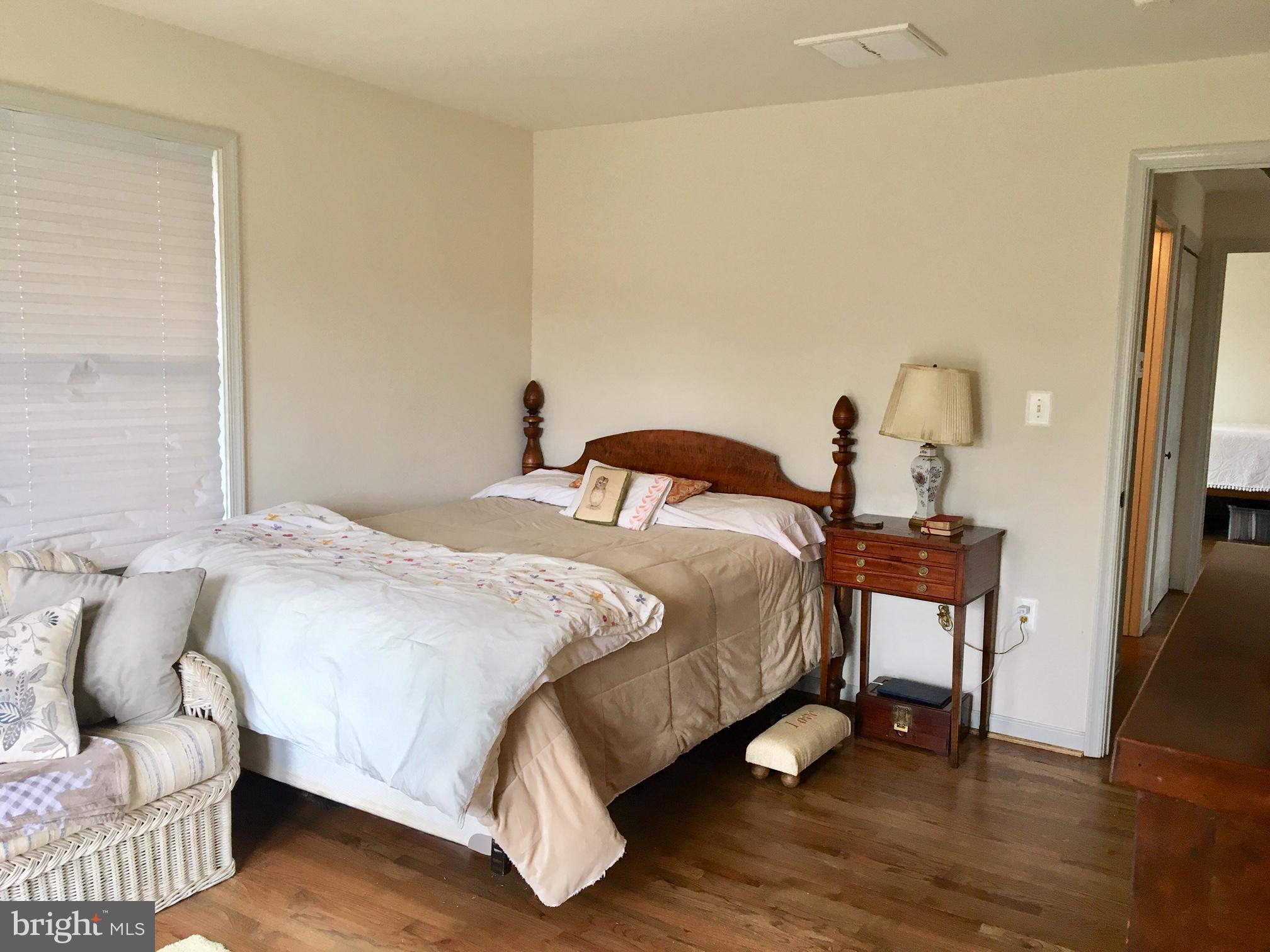 20022 Trappe Road Bluemont, VA 20135 - Photo 77 of 97 a bedroom with a bed and a dresser with wooden floor