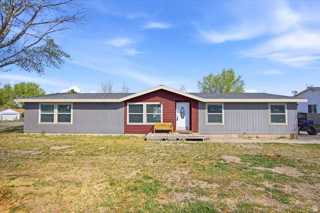 348 West 200 North Santaquin, UT 84655 - Photo 1 of 1 View of front facade featuring a wooden deck, a front yard, and a shingled roof
