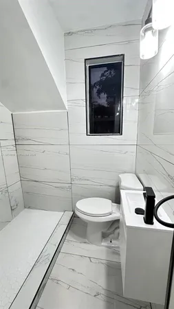a bathroom with a toilet a sink and mirror