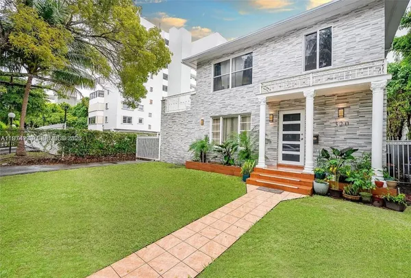 a front view of a house with a yard and plants
