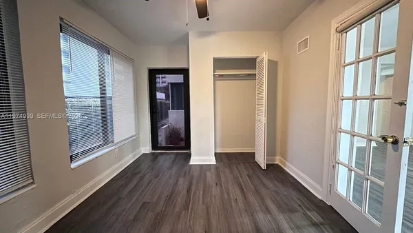 a view of a entrance and room with wooden floor