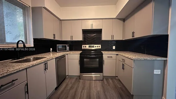 a kitchen with a sink stove and cabinets