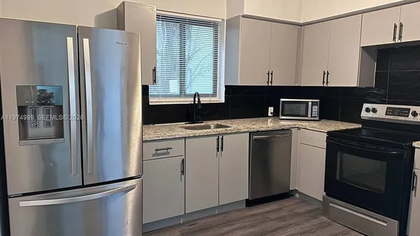 a kitchen with a refrigerator sink and cabinets