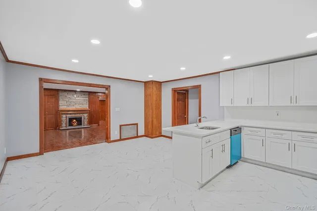a large white kitchen with granite countertop a sink dishwasher stove and cabinets